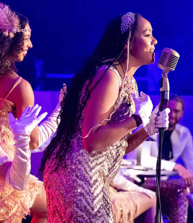 Woman in a dress with a microphone singing at an event