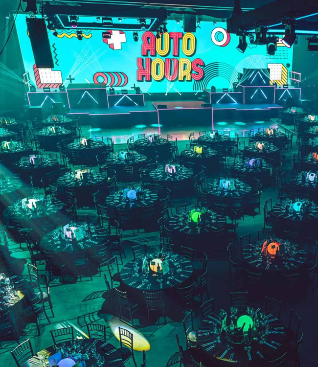 Aerial view of large conference centre interior with circular tables spread around in front of a stage